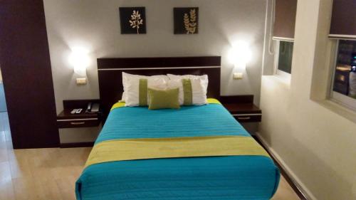 a bedroom with a large bed with two night stands at Hotel Misión Express Xalapa in Xalapa
