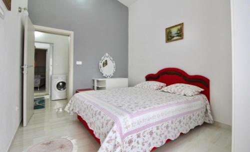 sypialnia z dużym łóżkiem z czerwonym zagłówkiem w obiekcie Apartment ANA w Barze