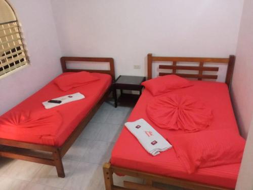 two beds with red sheets in a room at Hotel Panorama Neiva in Neiva