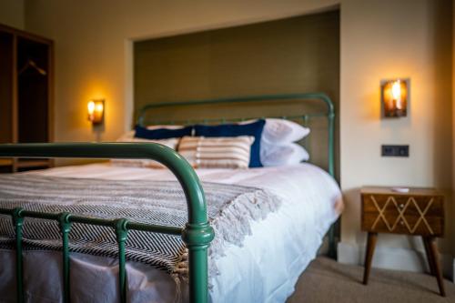 a bedroom with a bed with a green metal frame at Craig's Suites Windermere in Windermere