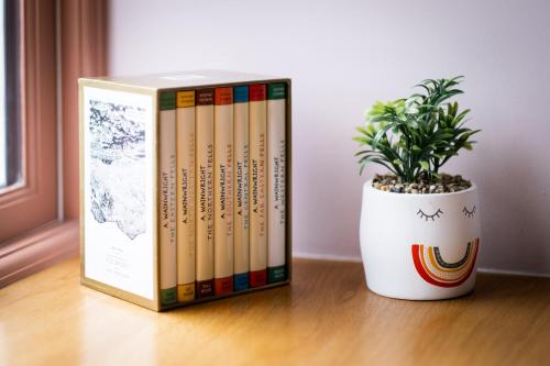a group of books sitting next to a potted plant at Craig's Suites Windermere in Windermere
