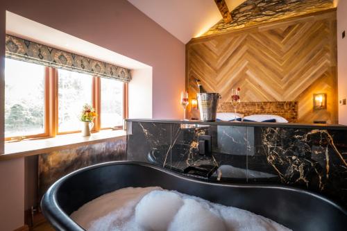 ein Bad mit einer schwarzen Badewanne und einem Waschbecken in der Unterkunft Craig's Suites Windermere in Windermere