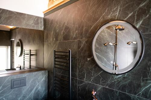 a bathroom with a round mirror and a sink at Craig's Suites Windermere in Windermere