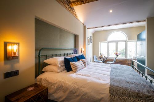 a bedroom with a bed with white sheets and blue pillows at Craig's Suites Windermere in Windermere