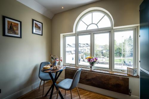 a dining room with a large window and a table and chairs at Craig's Suites Windermere in Windermere