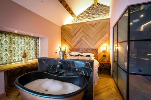a bathroom with a bath tub and a bedroom at Craig's Suites Windermere in Windermere