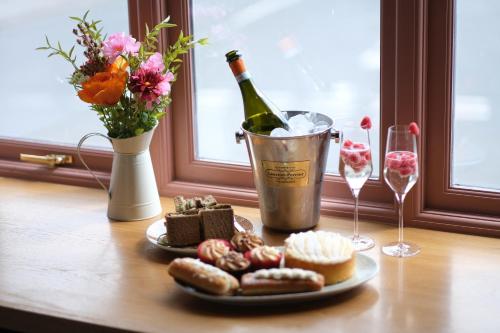 a table with a bottle of wine and a plate of food and wine glasses at Craig's Suites Windermere in Windermere
