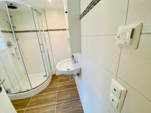 a white bathroom with a sink and a shower at Ferienhaus Biber in Godendorf
