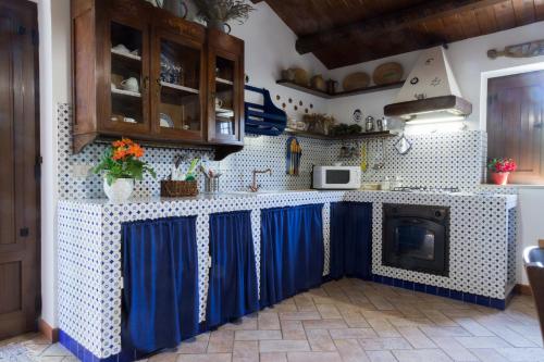 a kitchen with blue curtains on the counters at Terrazza sul Parco in Modica