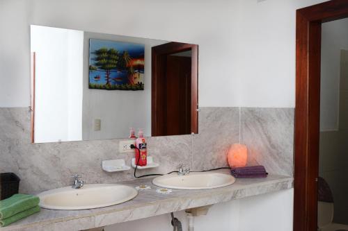 a bathroom with two sinks and a large mirror at Hostel las Palmas in Vilcabamba