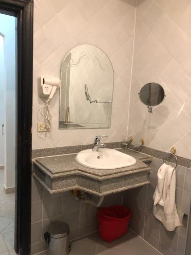 ein Badezimmer mit Waschbecken und Spiegel in der Unterkunft سهل حشيش in Hurghada