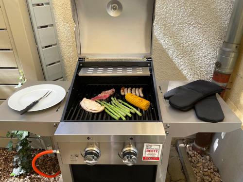 a grill with some meat and vegetables on it at SPACE AGE Design-Luxus-Apartment, Terrasse, Zentral in Gera