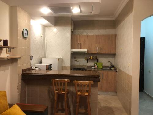 a kitchen with a counter and two chairs in it at سهل حشيش in Hurghada
