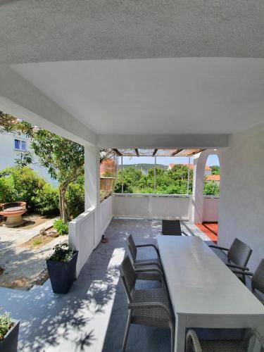 a dining room with a table and chairs on a patio at 6 M, 50 m do plaže in Barbat na Rabu