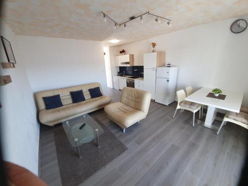 a living room with a couch and a table at 6 M, 50 m do plaže in Barbat na Rabu