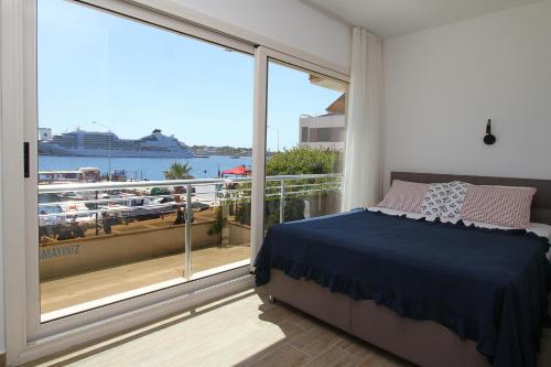 a bedroom with a bed and a balcony with a cruise ship at Ufuk Hotel in Cesme