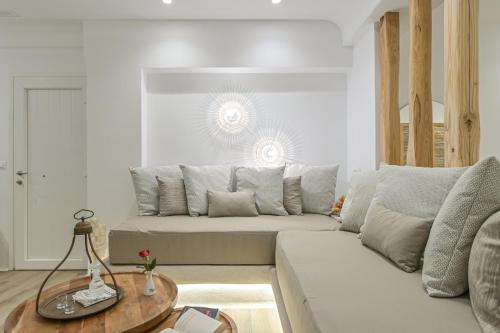 a living room with a white couch and a table at Villa Adriana Hotel in Agios Prokopios
