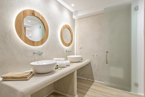 a bathroom with two sinks and a mirror at Villa Adriana Hotel in Agios Prokopios