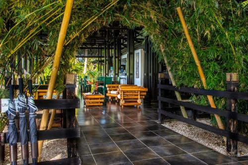 a restaurant with tables and chairs and a fence at Tiki Villas Rainforest Lodge - Adults Only in Uvita