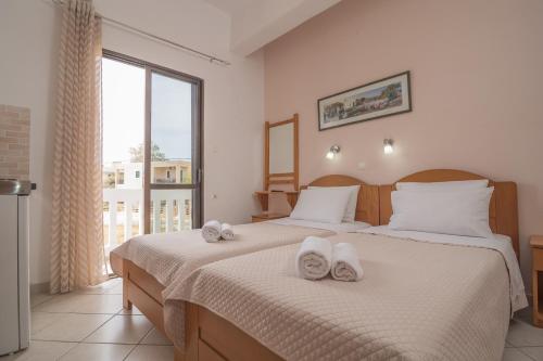 a bedroom with two beds with towels on them at Oriental Bay in Palaiochora