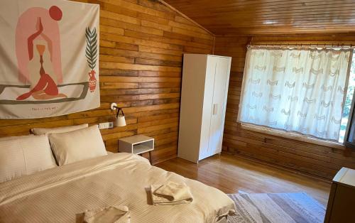 a bedroom with a bed in a room with wooden walls at Kibala Hotel in Cıralı