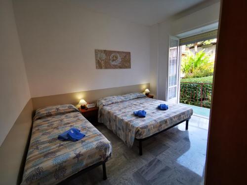 een slaapkamer met 2 bedden en blauwe handdoeken bij Casa Serena in Bordighera