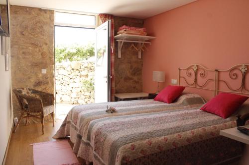 una camera da letto con un letto grande con cuscini rossi di Casa da Nininha a Vale de Cambra