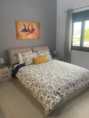 een slaapkamer met een bed en een schilderij aan de muur bij Georgia's house in Ária