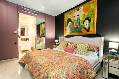 a bedroom with a bed and a painting on the wall at #2004 Cartwright - Glimmer Shimmer in Cape Town
