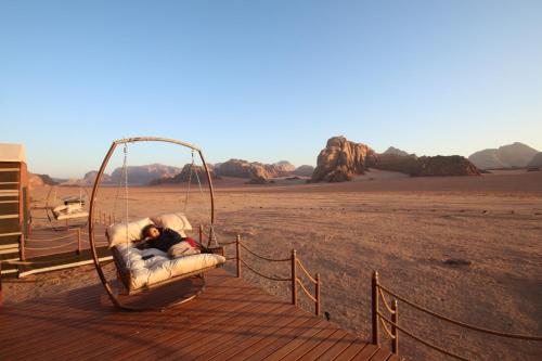 a person laying on a swing in the desert at Rum Stars Camp in Wadi Rum