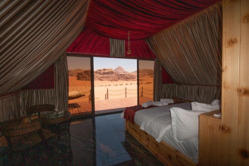 a bedroom with a bed and a view of the desert at Rum Stars Camp in Wadi Rum