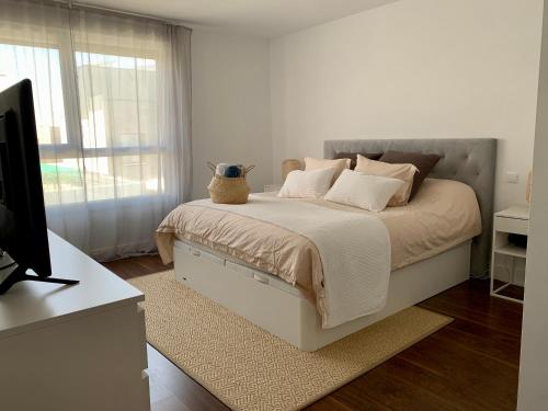 a white bedroom with a bed with a vase on it at Agradable chalet con piscina privada cerca de Madrid in Madrid