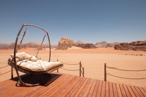 a swing on a deck with a view of the desert at Rum Stars Camp in Wadi Rum