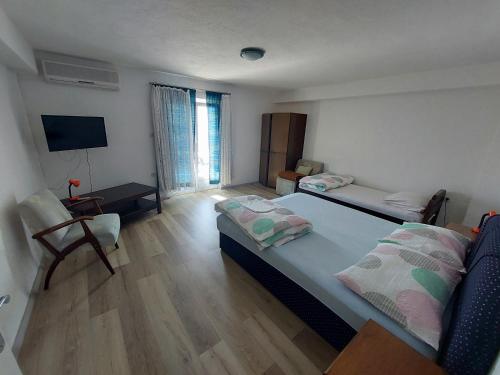 um quarto com uma cama, uma secretária e uma televisão em Apartment Boras em Senj