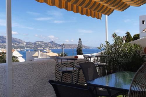 a patio with a table and chairs and a view of the ocean at House in the center of albir, 2 min walk from the beach in Albir