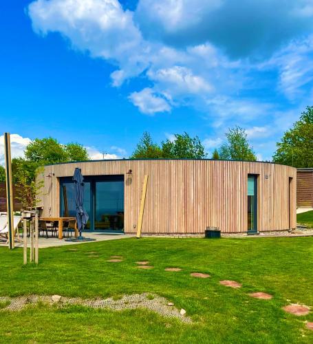 a wooden house with a lawn in front of it at Panorama Kořenec in Kořenec