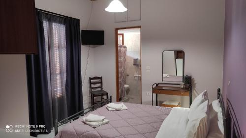 a bedroom with a bed and a desk and a mirror at Porto Sabatiki in Sampatiki