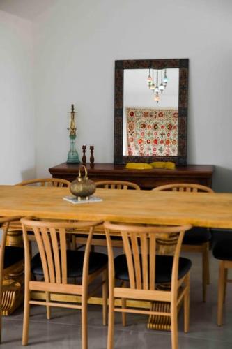 a wooden dining room table with chairs and a mirror at Spa Eilat Mountain Lodge in Eilat