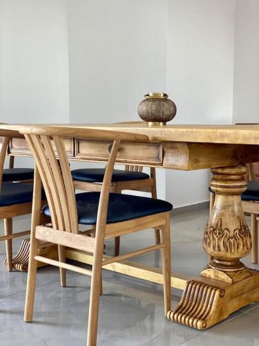 a wooden table with a wooden chair and a table with a bowl on it at Spa Eilat Mountain Lodge in Eilat