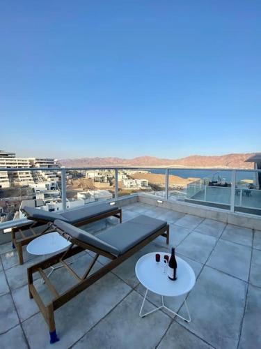 a patio with a table and a bottle of wine at Spa Eilat Mountain Lodge in Eilat
