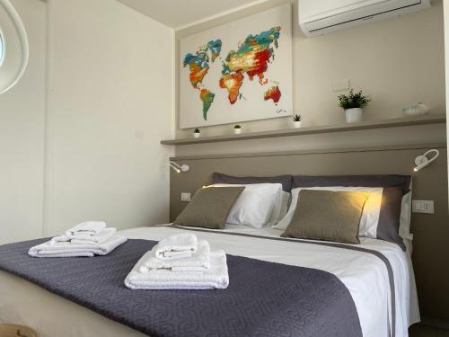 a bedroom with a bed with towels on it at Mansarda - SUNSET in Torre Pali 