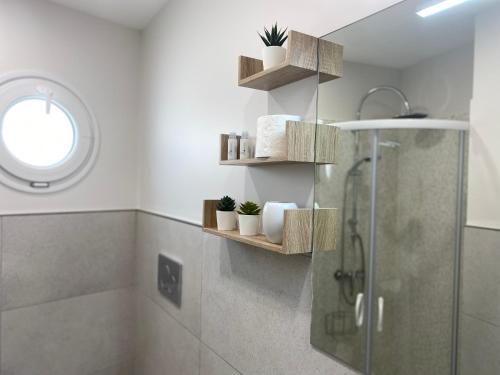 ein Badezimmer mit einer Dusche und einigen Holzregalen in der Unterkunft Stupenda Mansarda vista Mare in Torre Pali 