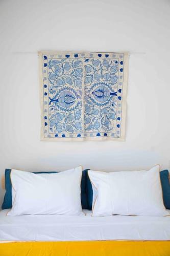 a bed with two pillows and a picture on the wall at Spa Eilat Mountain Lodge in Eilat