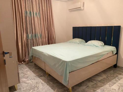 uma cama com uma cabeceira azul num quarto em Charmant appartement - residence avec piscine entre Hammamet et Nabeul em Nabeul