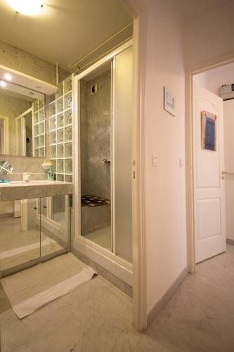 une salle de bain avec une douche en verre et un lavabo dans l'établissement Victoria Appartement, à Menton
