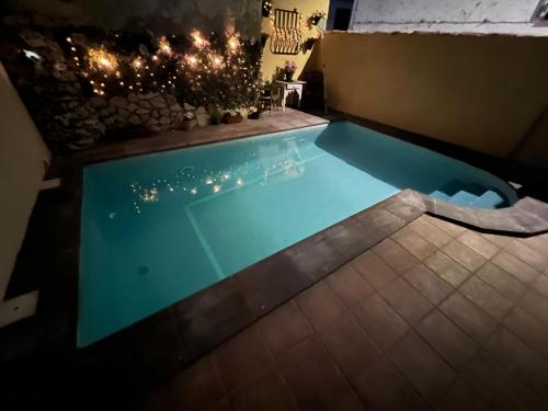 ein Schwimmbad in der Nacht mit Weihnachtsbeleuchtung in der Unterkunft Casa Rural la Abuela Amelia in Garcinarro