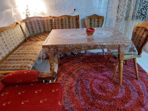 mesa de comedor y sillas con alfombra roja en Airport home Radinovic en Podgorica