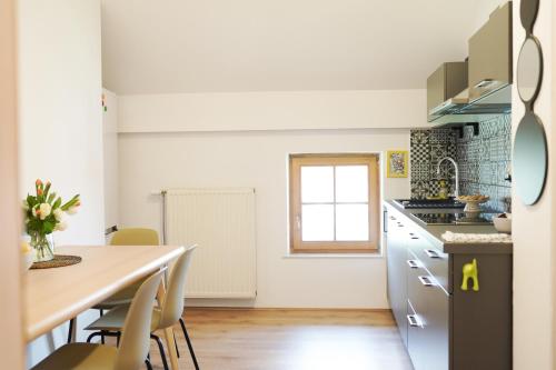 a kitchen and dining room with a table and chairs at Fado Apartments Gornja Radgona in Gornja Radgona