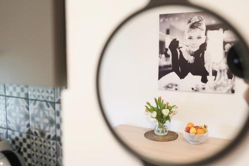 a mirror reflection of a table with a bowl of fruit at Fado Apartments Gornja Radgona in Gornja Radgona