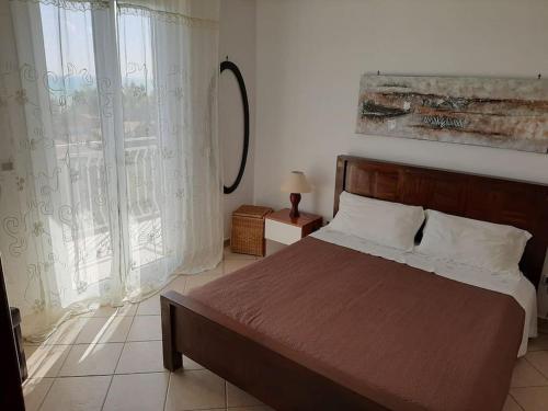 a bedroom with a bed and a large window at Villa Emily in Licata